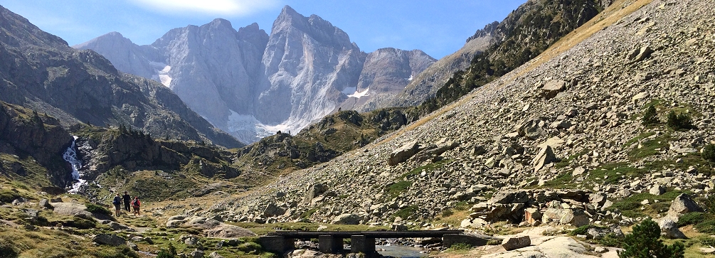 Hikers in the Gaube Valley gaze at the north face of Vignemale, French Pyrenees.